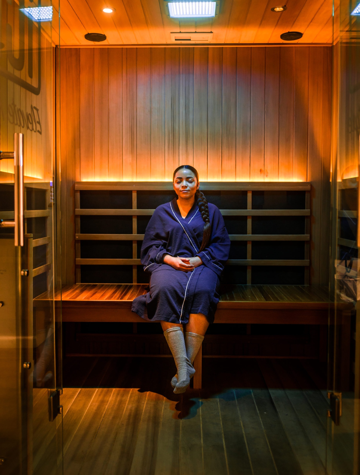 Woman relaxing in the infrared sauna cabin at iCRYO Grosse Pointe